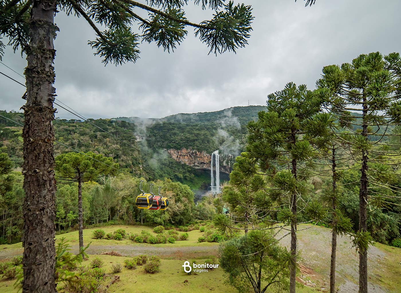 Bondinhos em meio a natureza da Serra Gaúcha com cachoeira de fundo