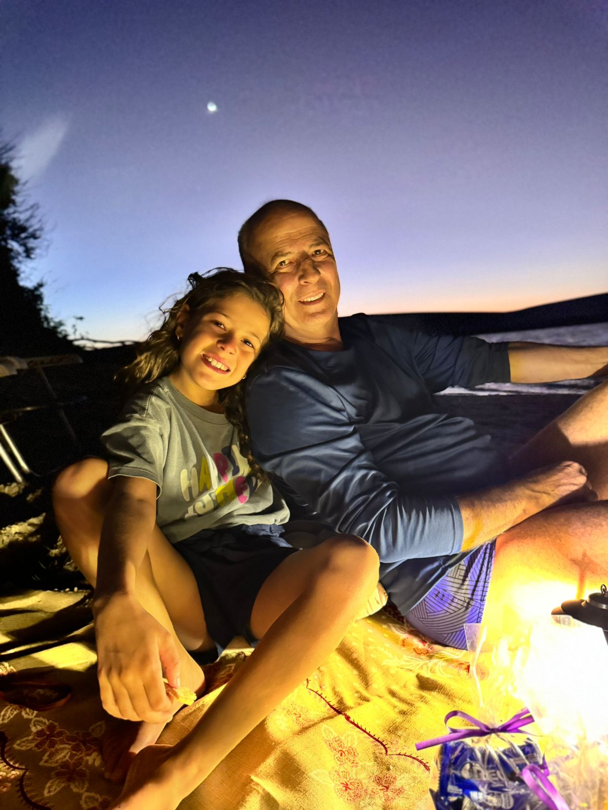 Pai e filha aproveitando o momento sob o luar nas dunas de Jericoacoara