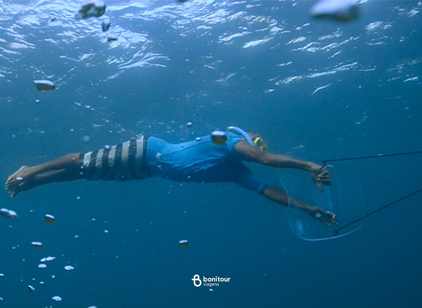 Pessoa realizando o mergulho aqua sub reboque em mar de Fernando de Noronha
