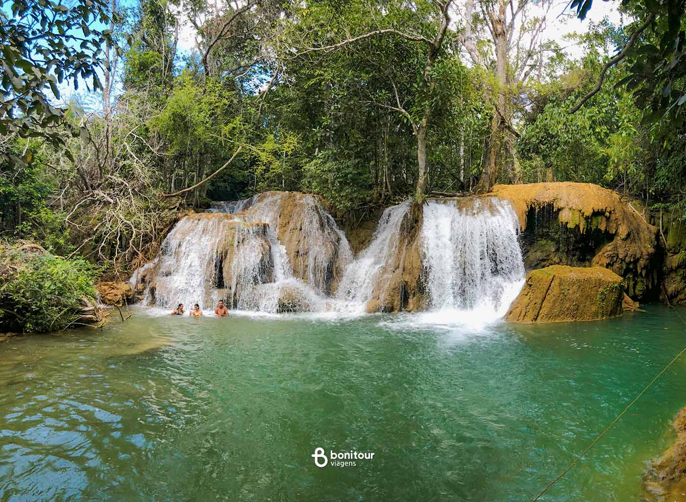 Várias pessoas se banhando em águas de cachoeira na região de Bonito/MS