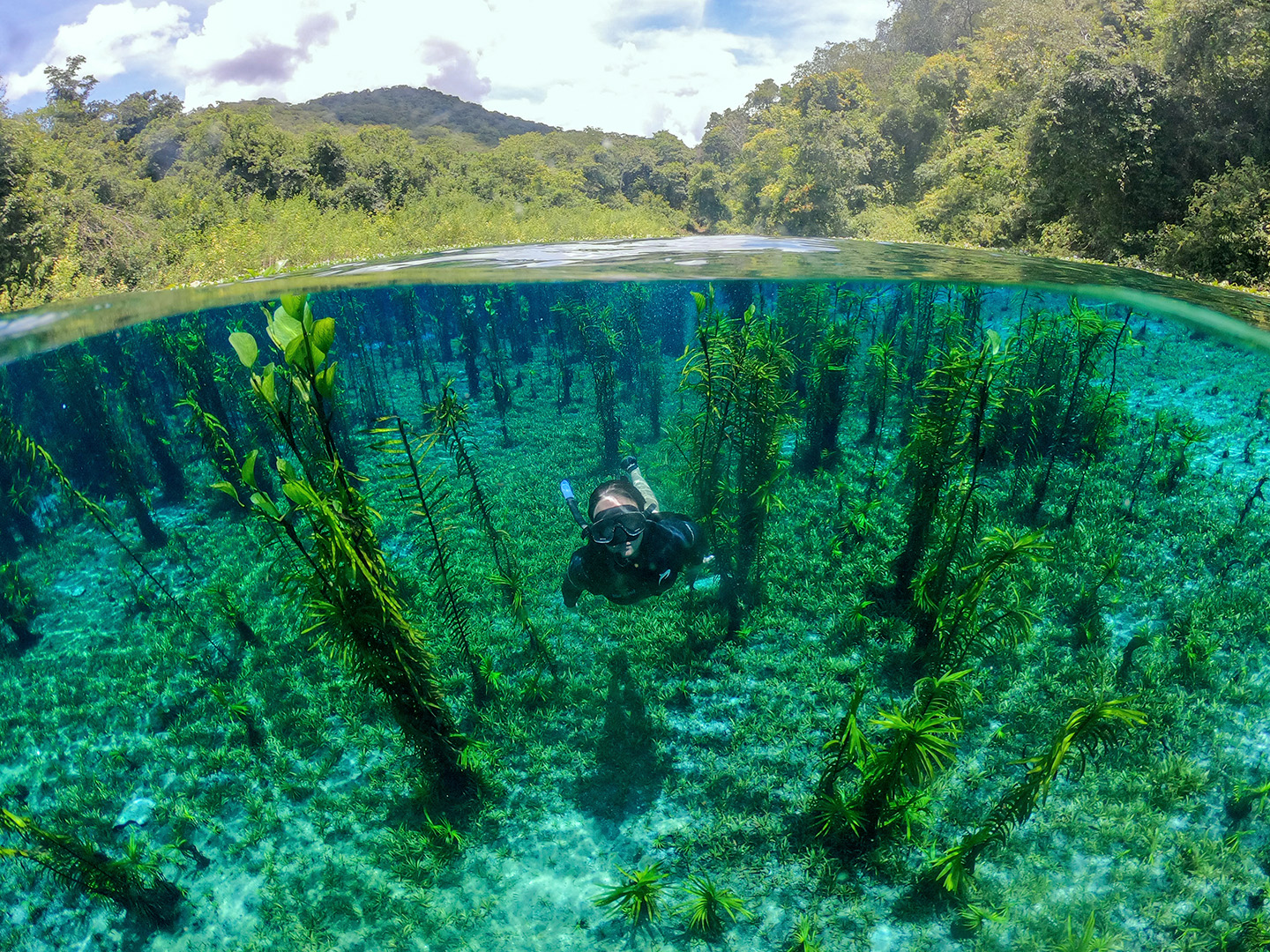 menina realizando flutuação no rio azul
