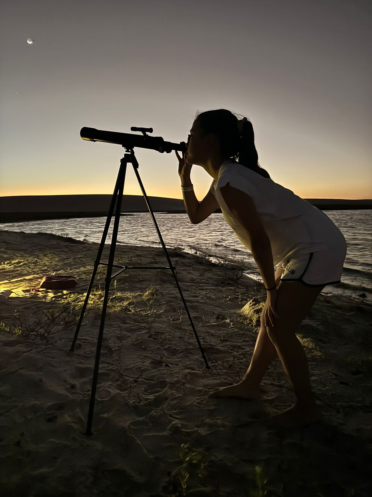 Participante observando o céu por telescópio astronômico em Jericoacoara