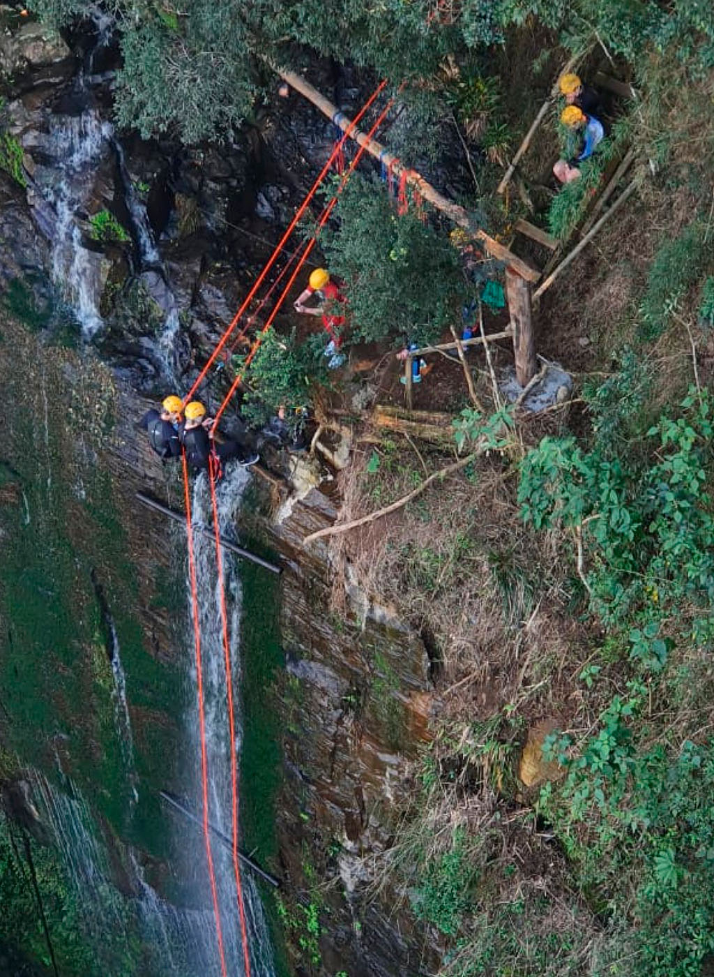 Pessoas descendo de Rapel em meio a Natureza