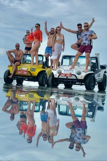 Turistas sobre buggies refletidos na água durante passeio exclusivo Jericar Viagens