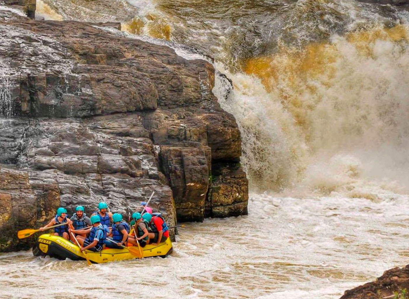 Pessoas praticando Rafting no Rio das Antas, com grande pedra de fundo