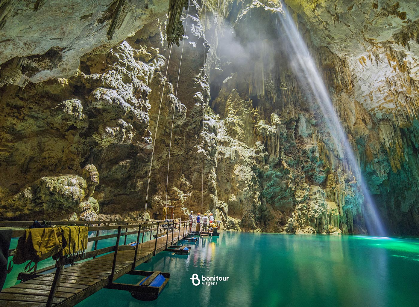 Deck de madeira do Abismo Anhumas com águas cristalinas e formações rochosas