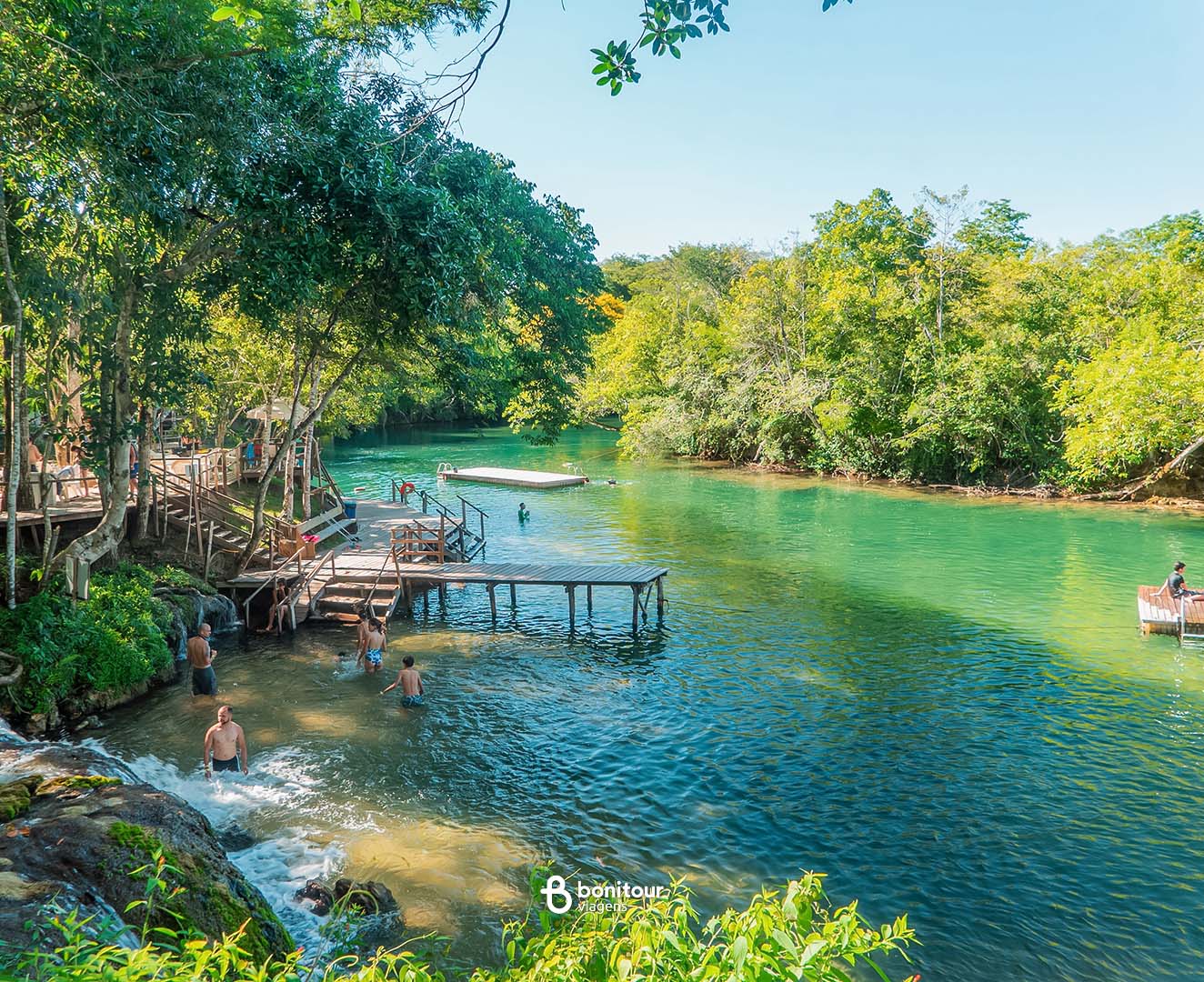 Deck de madeira a beira de águas cristalinas e cachoeira