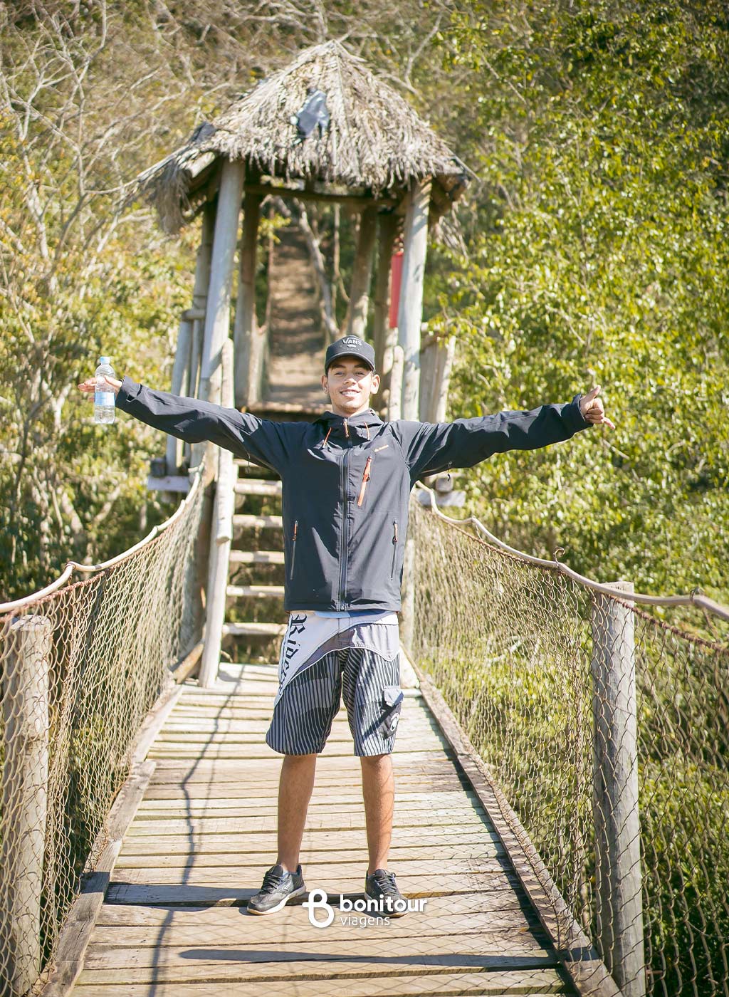 Pessoa de braços abertos em trilha a caminho da Gruta Catedral