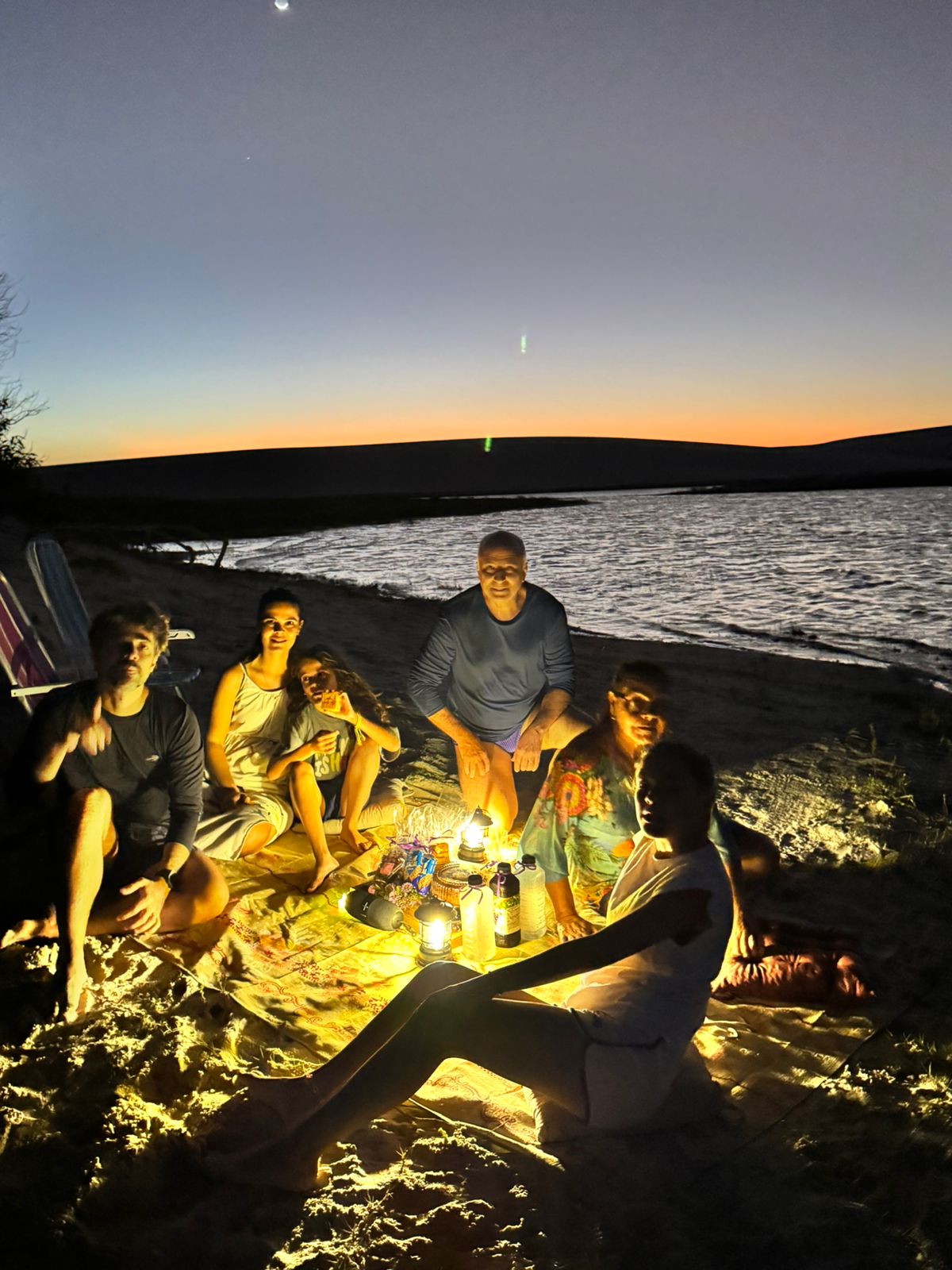 Grupo reunido ao redor da luz em noite de observação astronômica Mirar das Estrelas
