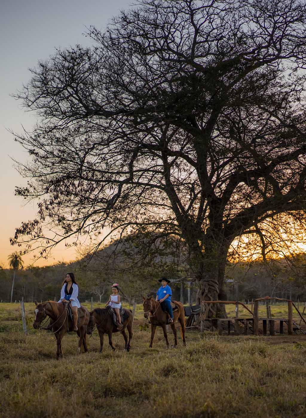 Pessoas cavalgando em entardecer de Bonito