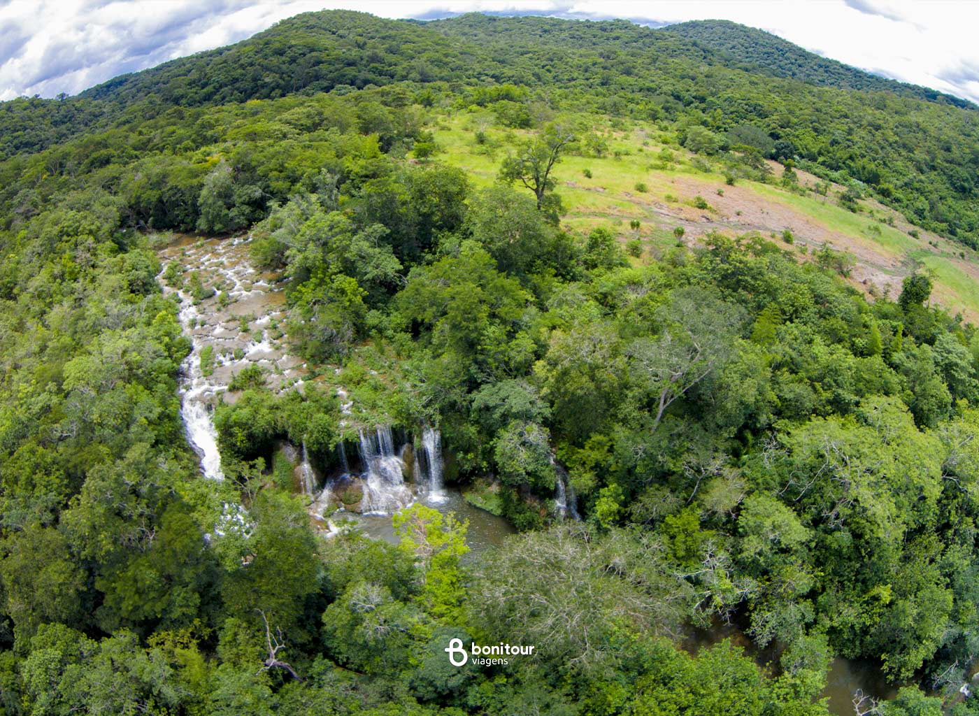 Vista aérea de quedas d'água de cachoeira em meio à mata nativa em Bonito/MS.