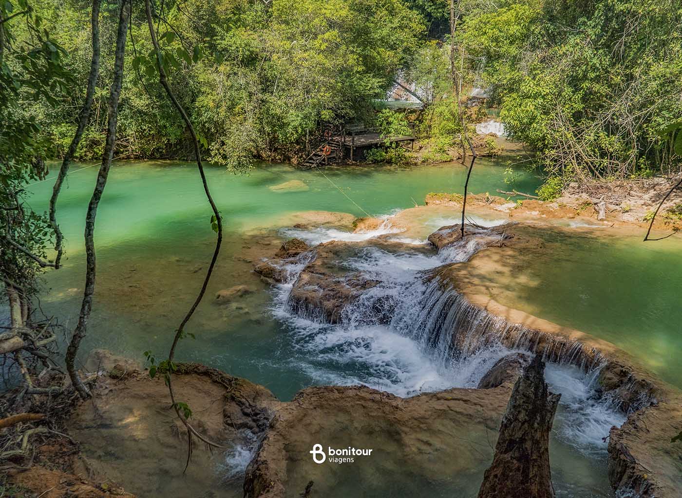 Vista de quedas d'água e águas cristalinas em meio à vegetação abundante em Bonito/MS.