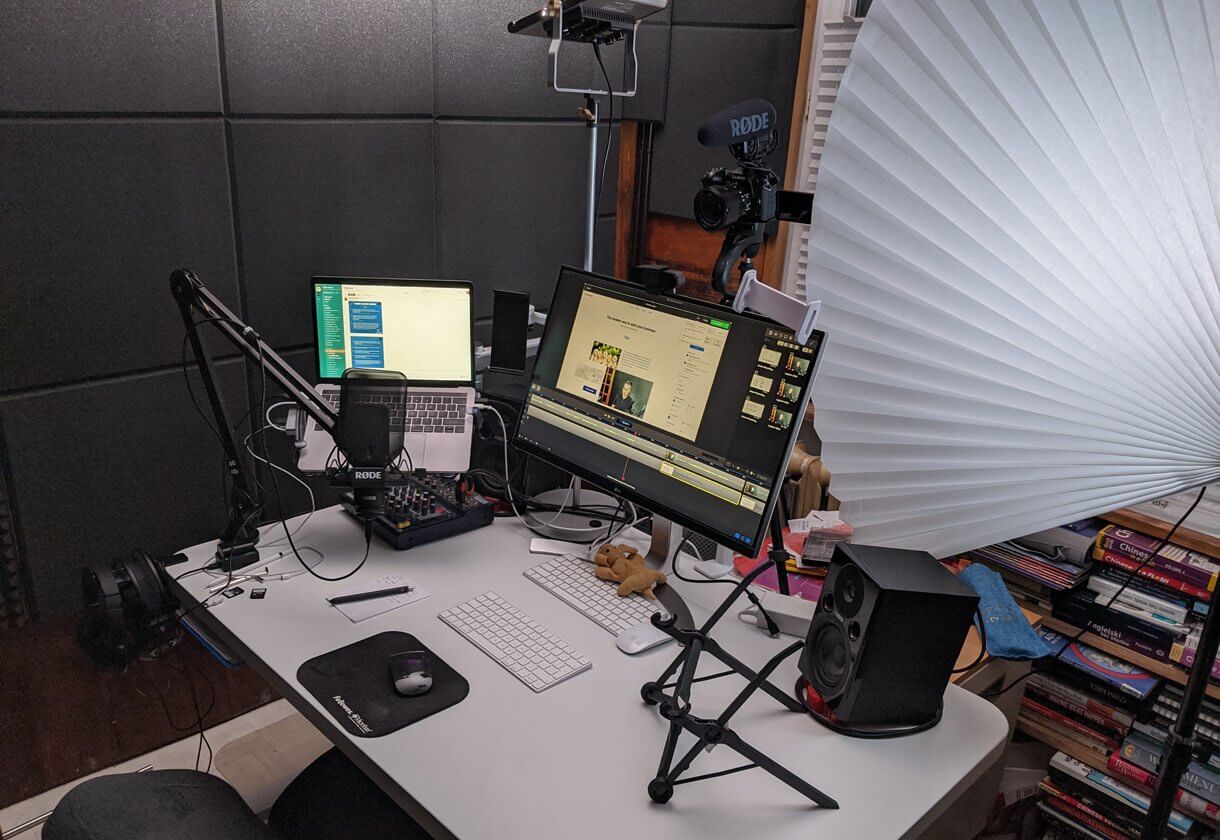 wfh setup for video and webinar creation - MacBook Pro, external monitor, microphone, lighting, soundproof wall, video camera