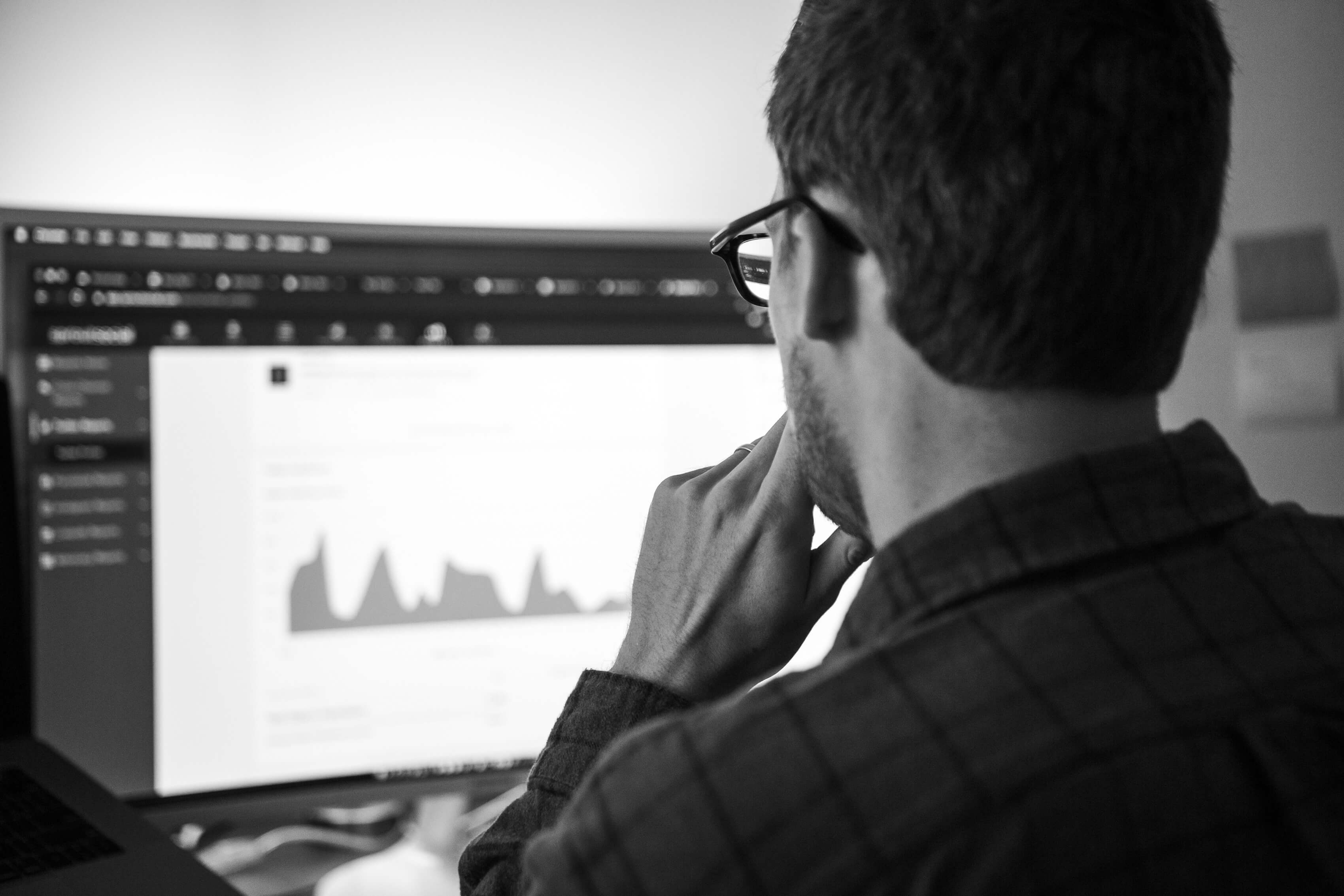 A strategist studying an analytics dashboard on a monitor