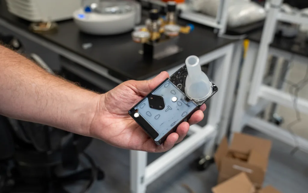 Tom Cirrito holding the prototype breath-based diagnostic device
