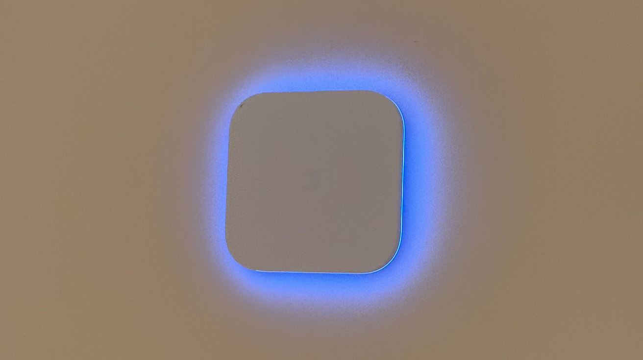 Close up of a UniFi access point or security device showing a glowing blue square LED border