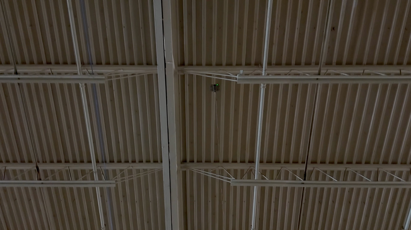 High angle view of warehouse roof trusses during initial network cable path planning