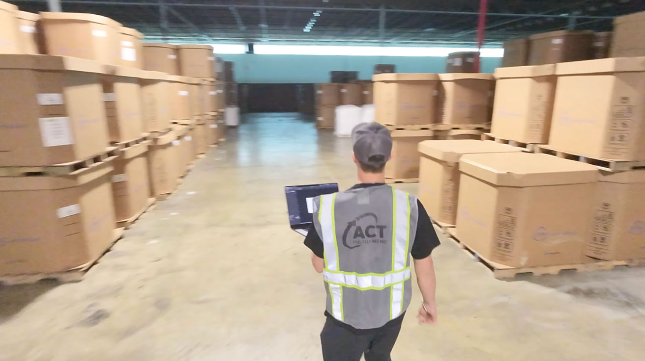 Technician walking through warehouse racks conducting a NetSpot Wi-Fi site survey