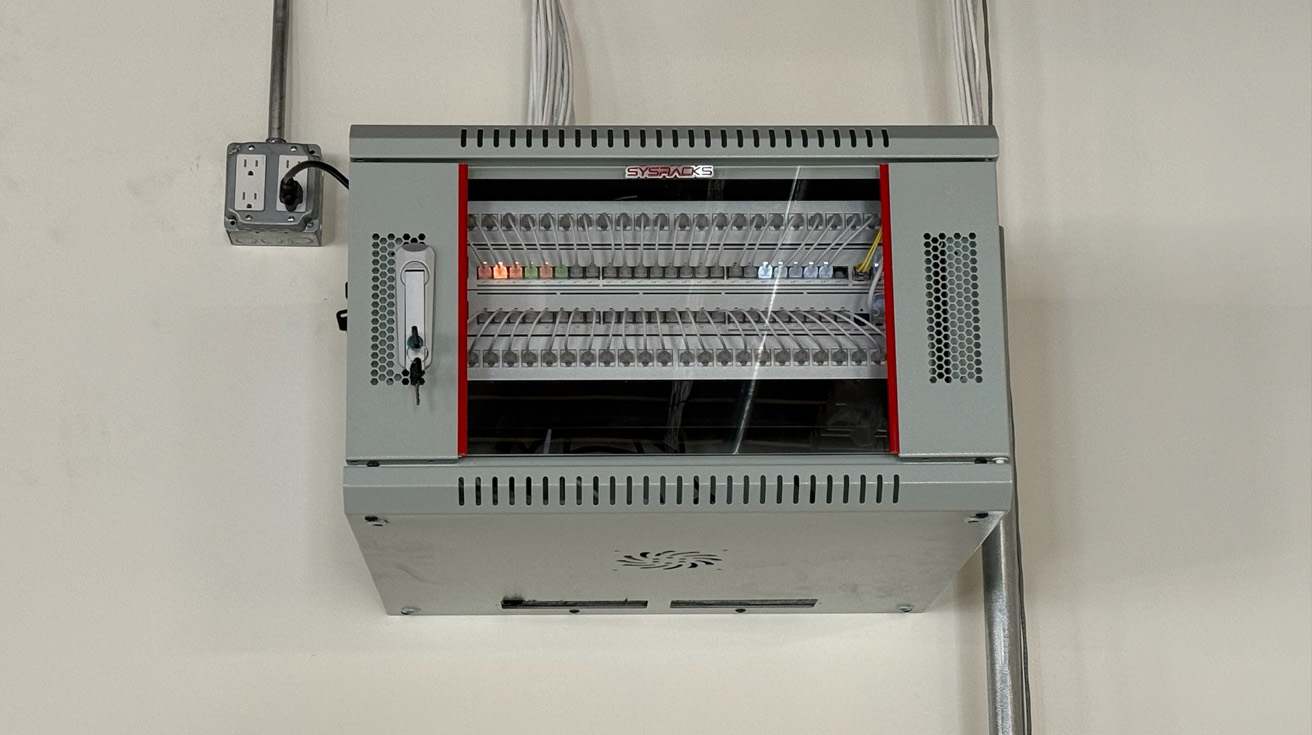 a wall mounted telecommunications cabinet showing neatly organized structured cabling and professional physical layer triage.