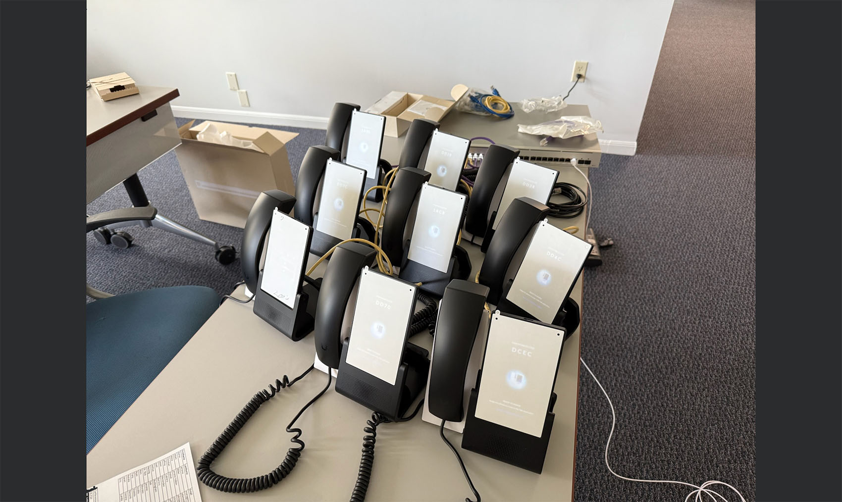 Multiple UniFi Talk IP phones undergoing mass provisioning, firmware updates, and network validation prior to corporate deployment.