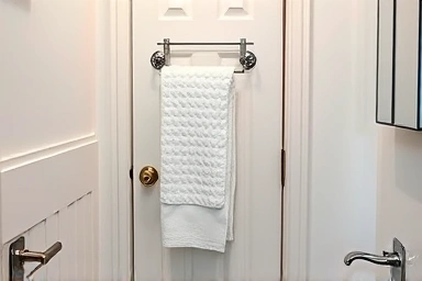 Small bathroom with efficient over-the-door towel rack maximizing space.