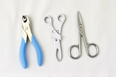 Newborn nail care kit with clipper, scissors, and file.