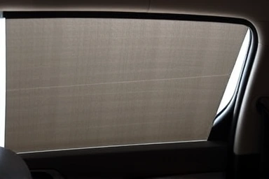 Close-up of car window with effective blackout curtain blocking sunlight