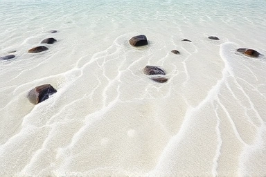 Clear shallow waters of Hyeopjae Beach, white sand, volcanic rocks