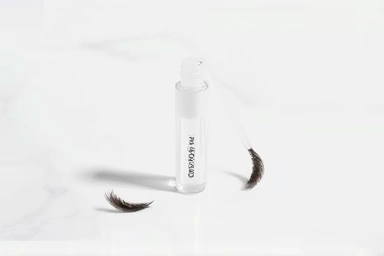 Sleek brow fixer tube and applicator with artfully placed brow hairs.