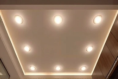 Symmetrical recessed lighting arrangement in a living room ceiling.