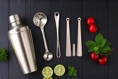 Professional bar tools and fresh garnishes neatly arranged for cocktail preparation.