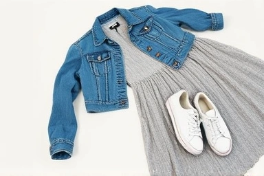 Denim jacket, maxi dress, and sneakers arranged stylishly