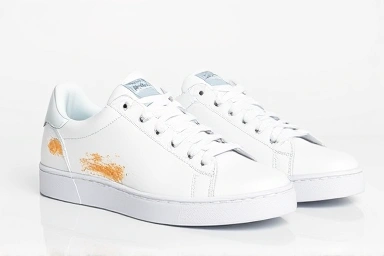 White sneakers, one stained, one perfectly clean.