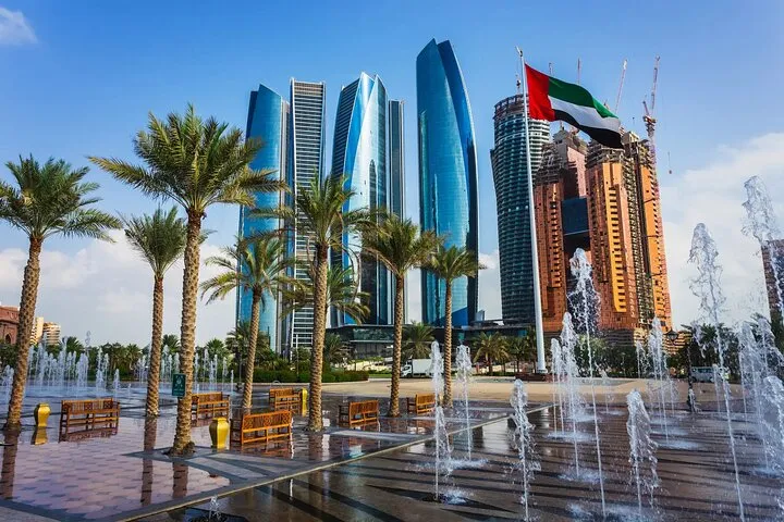 Abu Dhabi skyscrapers, palm trees, fountains, UAE flag.
