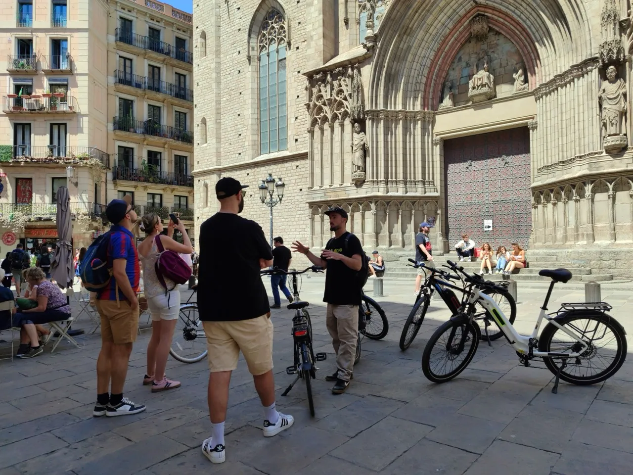 Barcelona Cathedral plaza with tourists and bikes.