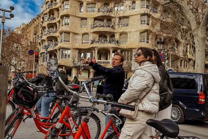 People sightseeing Gaudi's Casa Milà, Barcelona, with bikes.