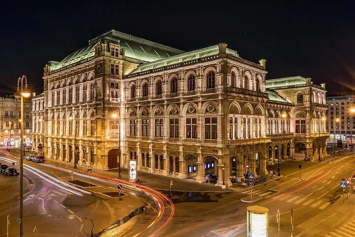Vienna State Opera building illuminated at night.