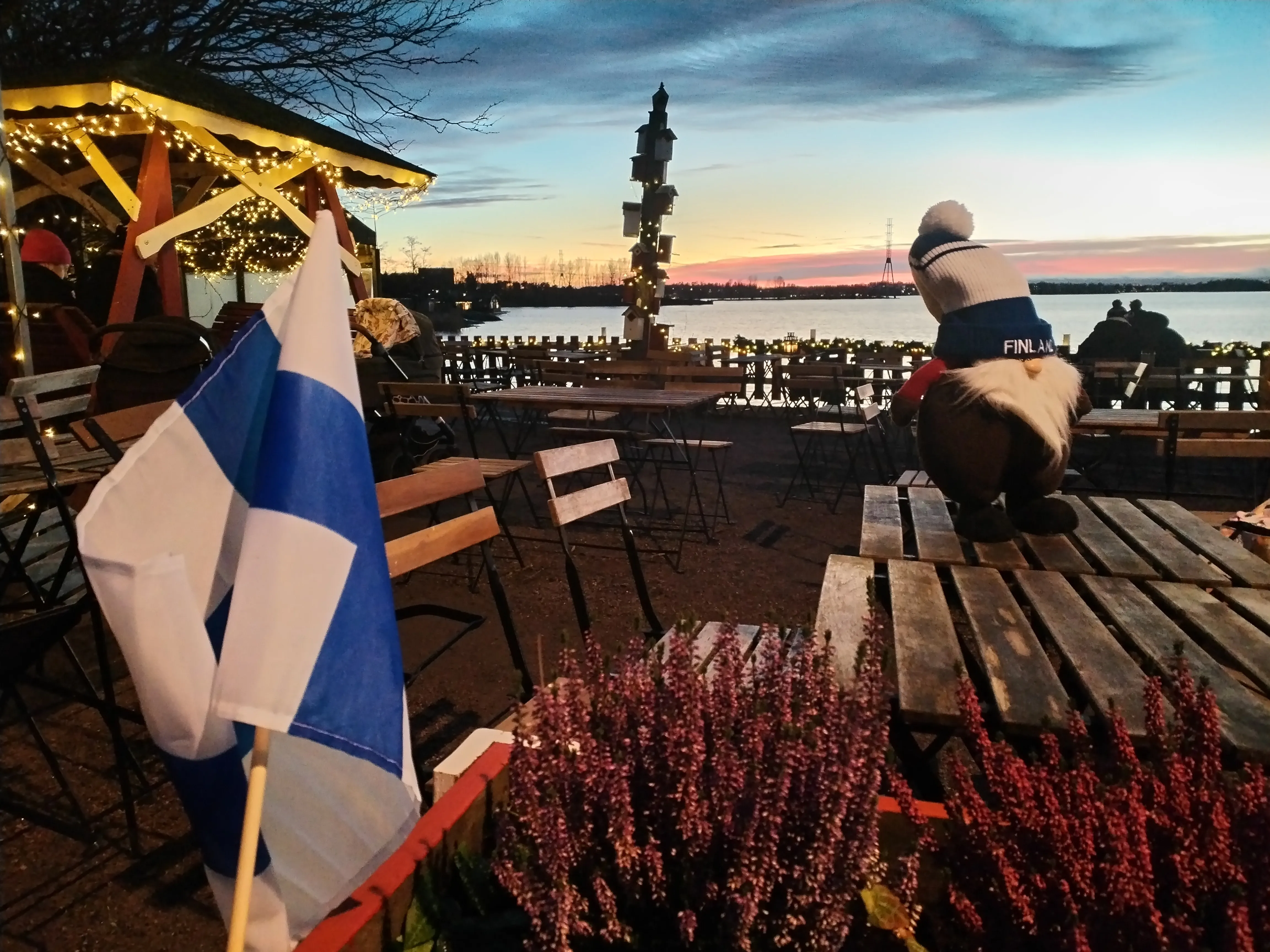 Lakeside cafe, Finnish flag, gnome, sunset.