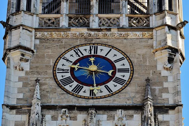 Ornate gothic tower clock face with sun.