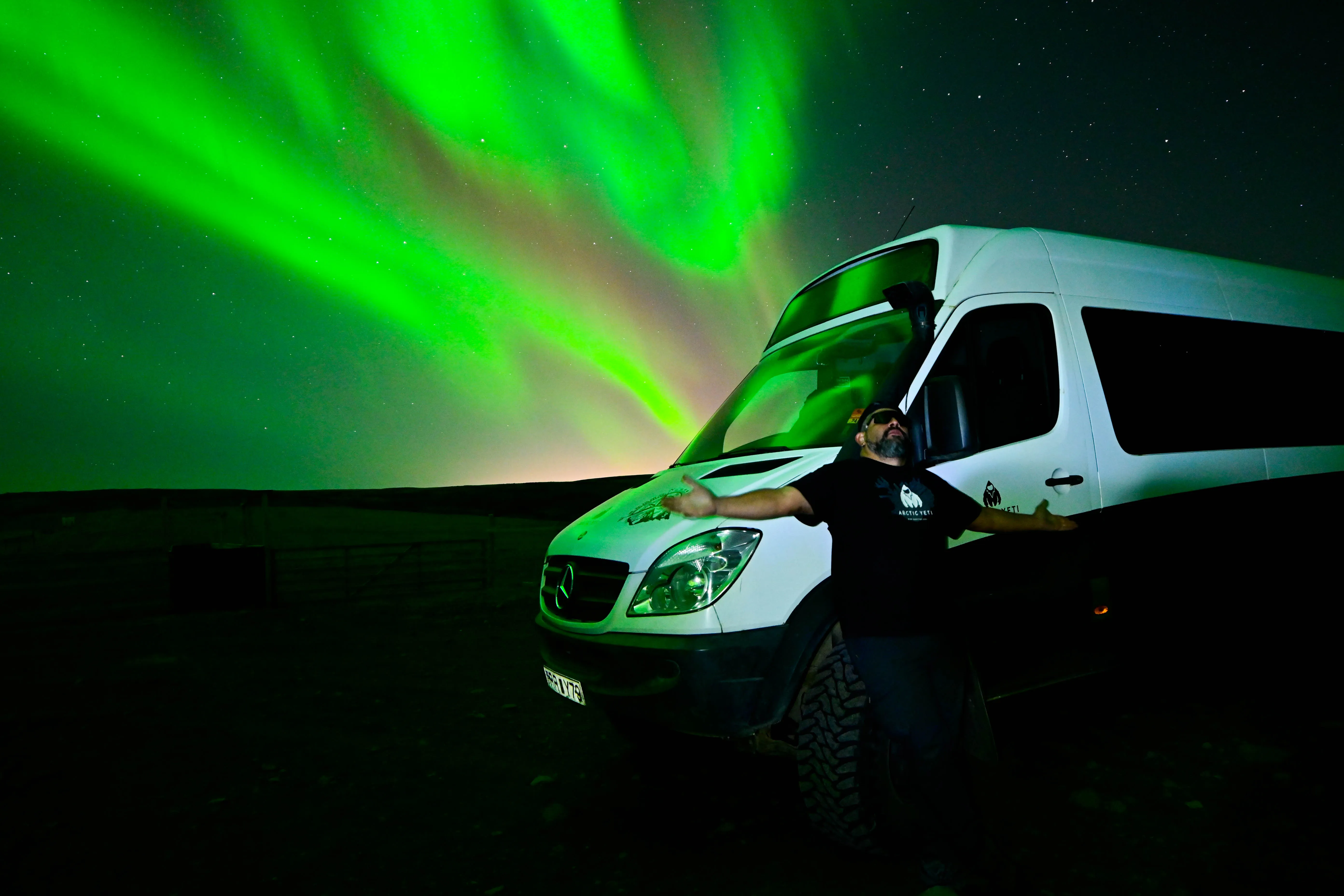 Camper van, man, green Northern Lights.