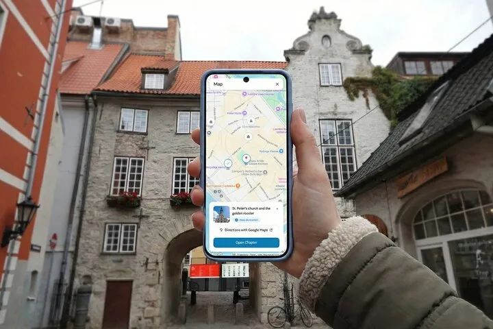 Hand holds smartphone with map in historic European town.