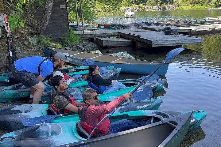 Group preparing for kayaking on lake.