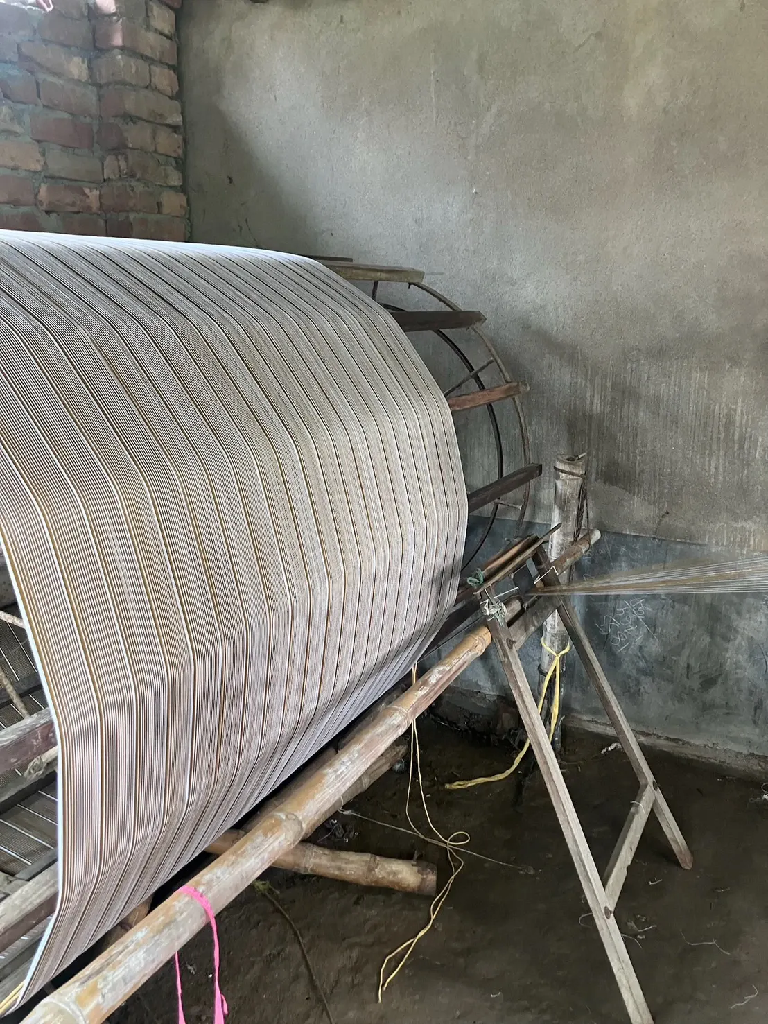 Striped warp threads wound onto a large beam, waiting to be set on the loom