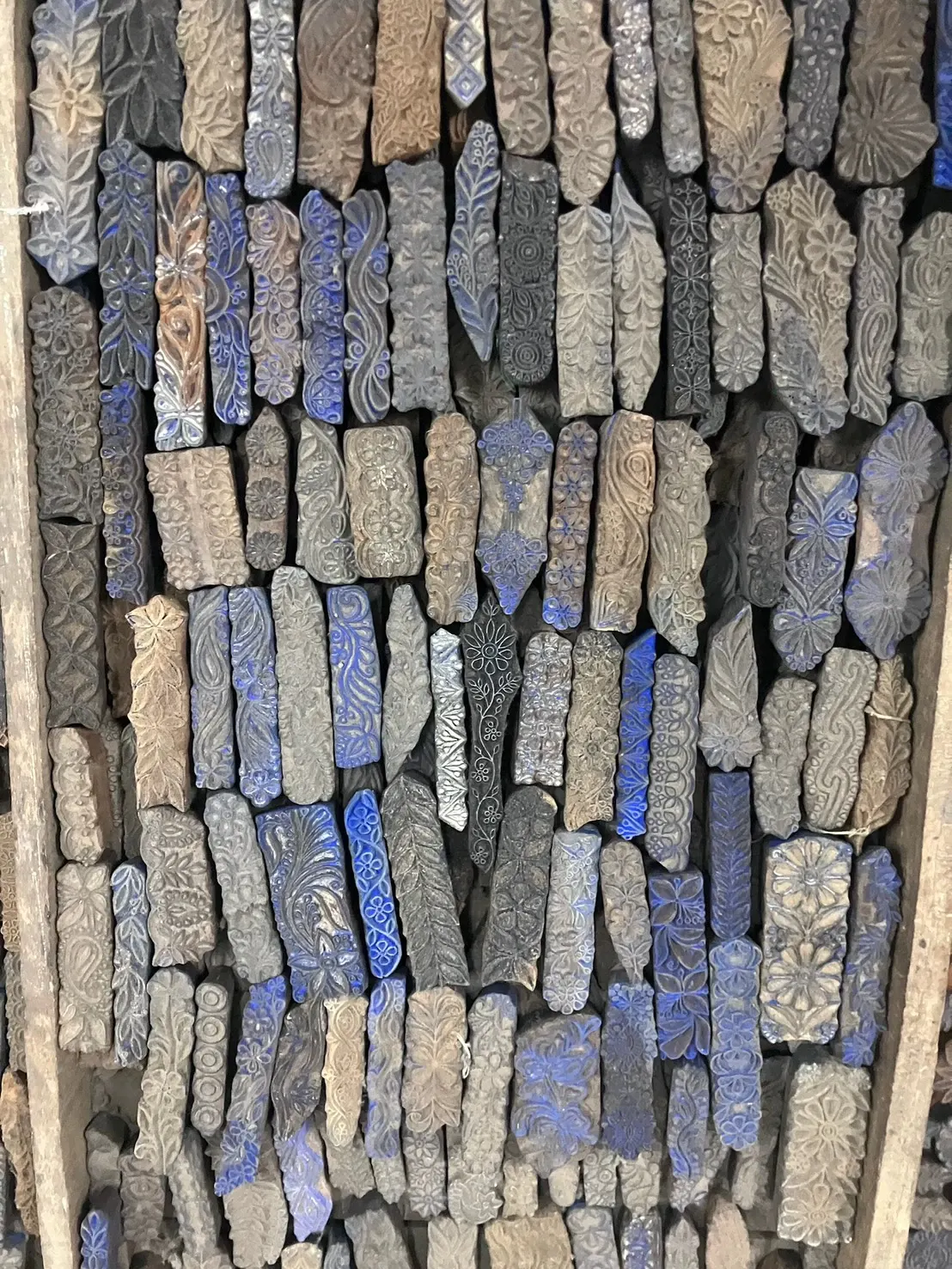 Carved wooden printing blocks packed into the shelves of a workshop