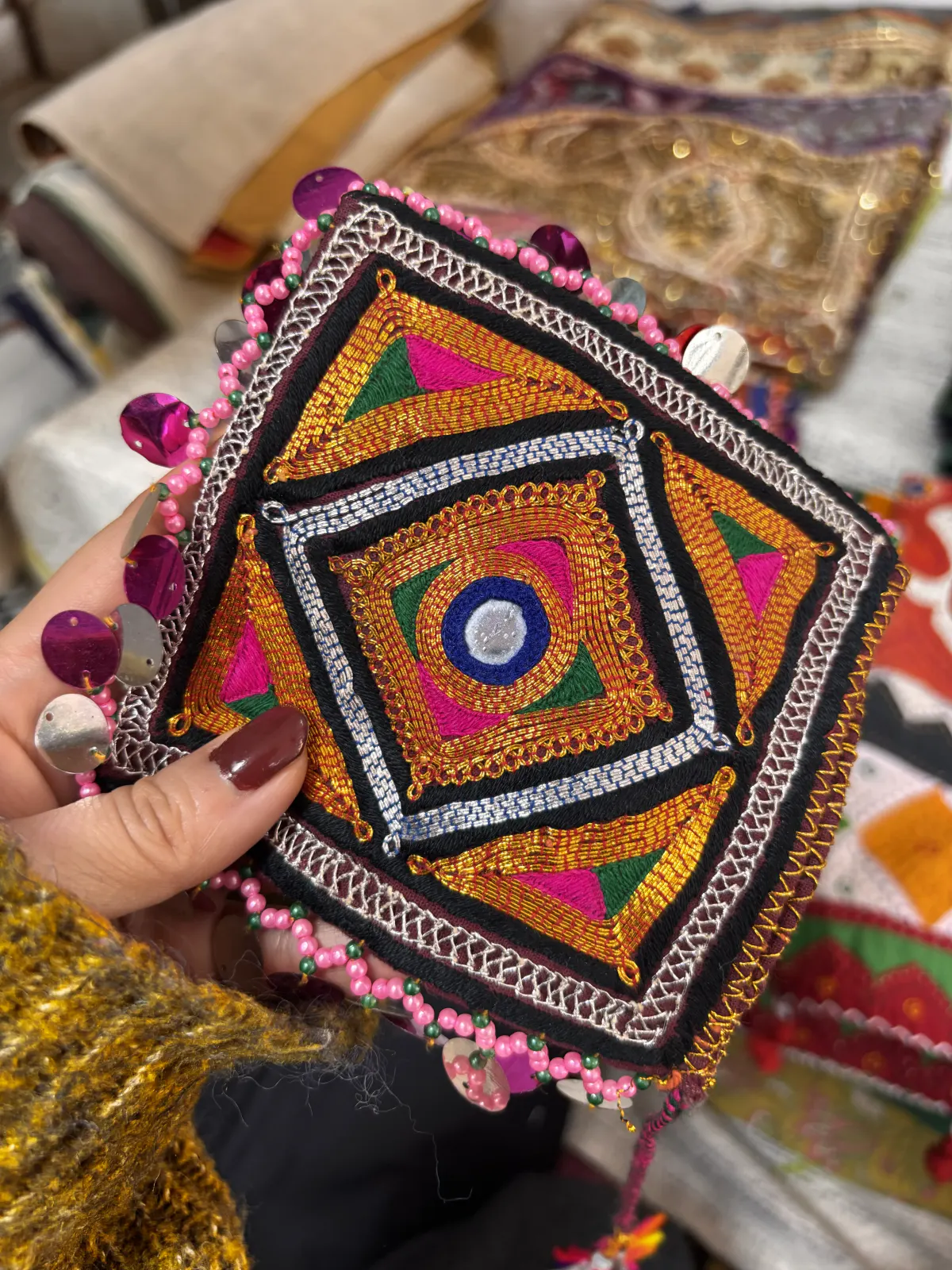 A palm-sized pouch worked in geometric mirror embroidery