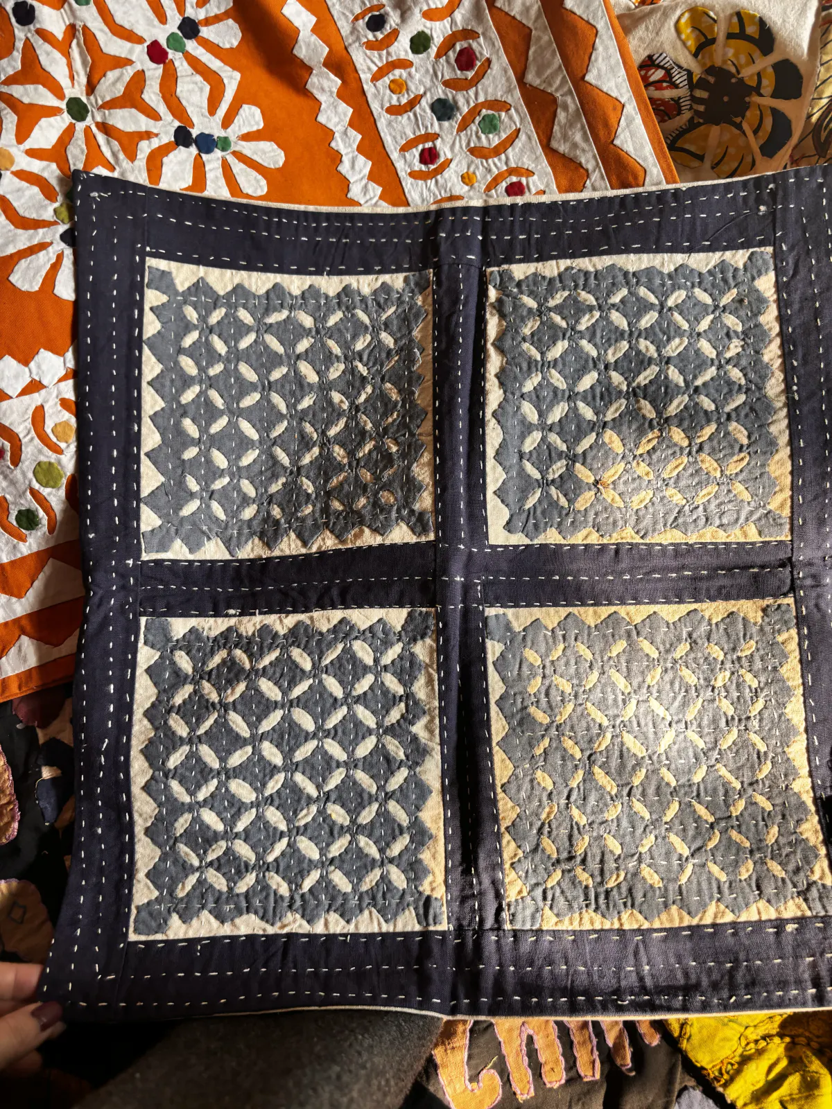 A patchwork panel of indigo checked cloth layered with white sashiko stitching