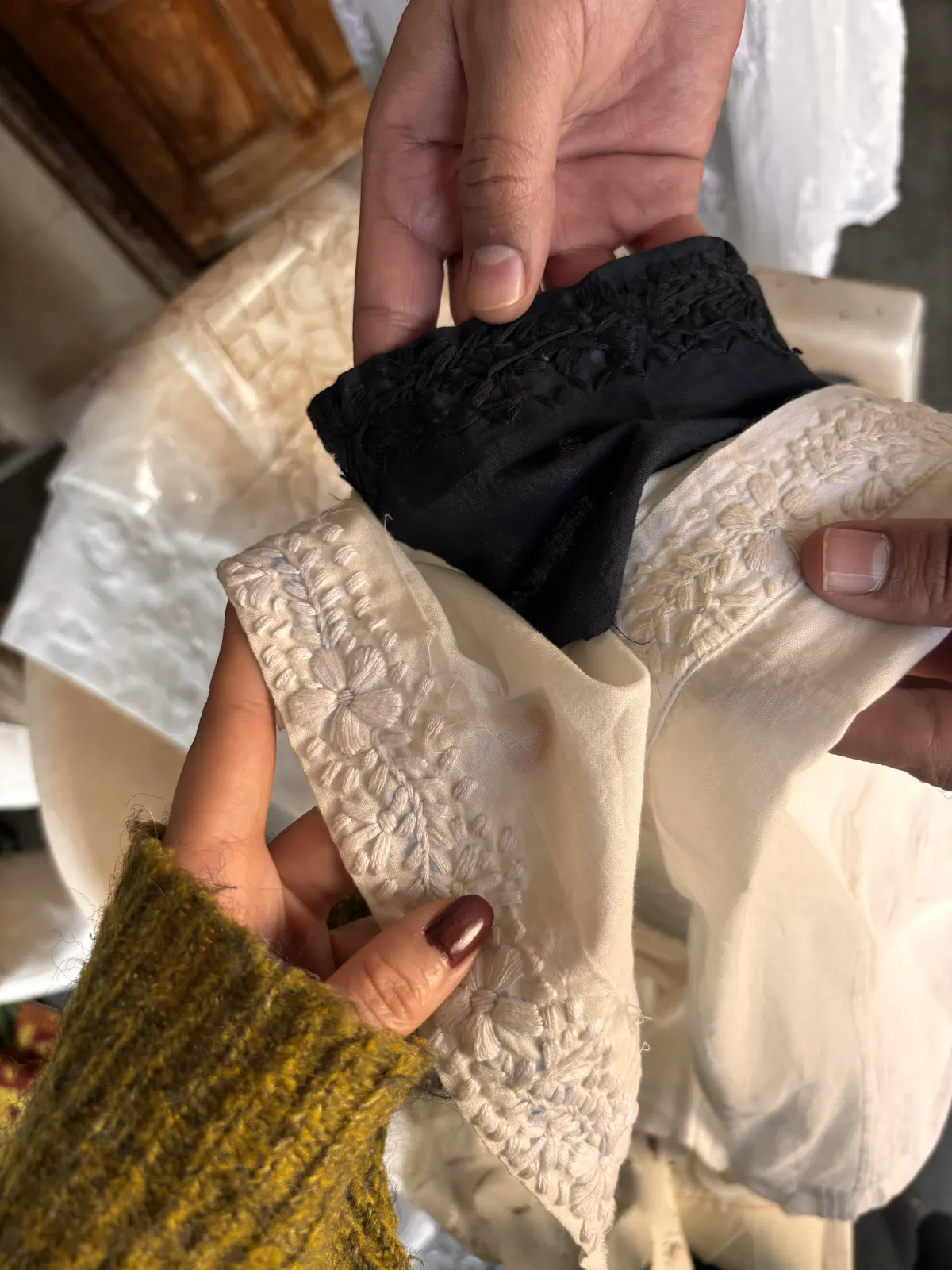 Black and undyed embroidered swatches held side by side, compared for their handle