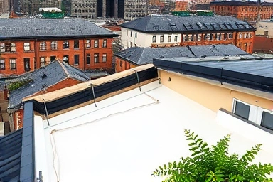 Reflective cool roof coating deflecting sunlight, saving energy.