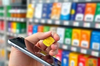 Hand inserting SIM card into smartphone, convenience store in background.