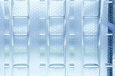 Close-up of air bubble insulation film on a window, showing air pockets.